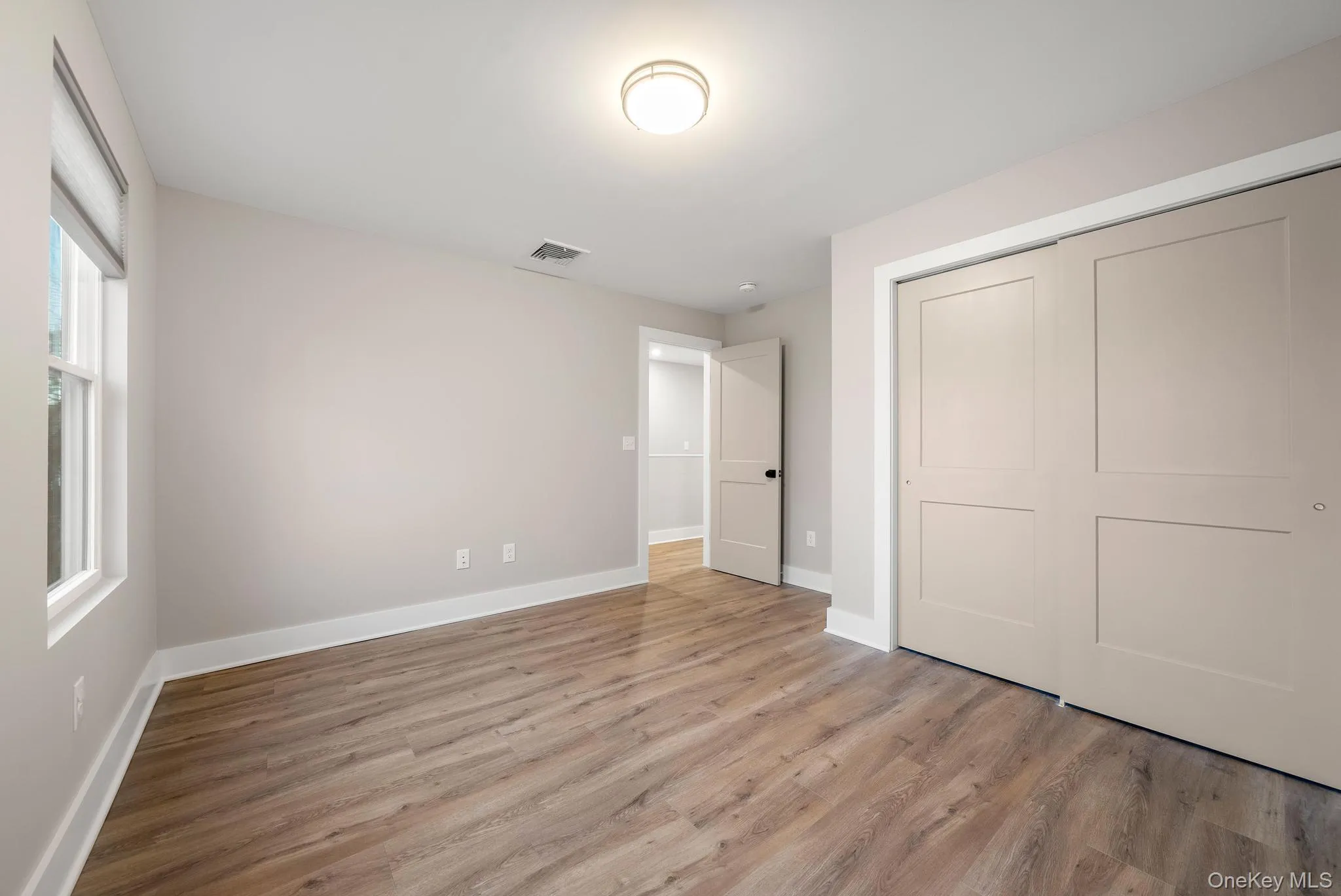 Unfurnished bedroom with light wood-style floors and a closet Unfurnished bedroom with light wood-style floors and a closet