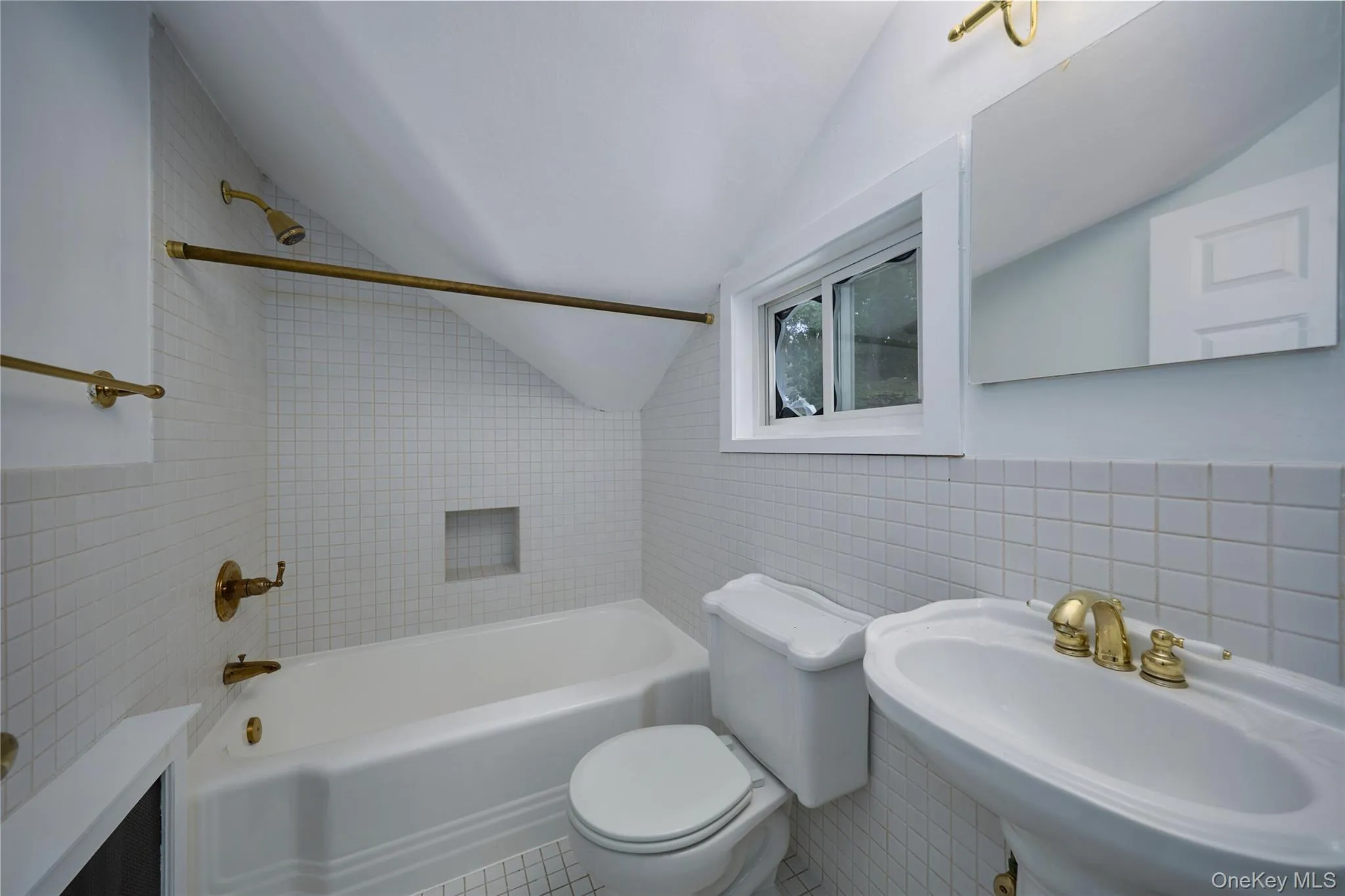 Bathroom featuring tile walls, washtub / shower combination, and lofted ceiling Bathroom featuring tile walls, washtub / shower combination, and lofted ceiling