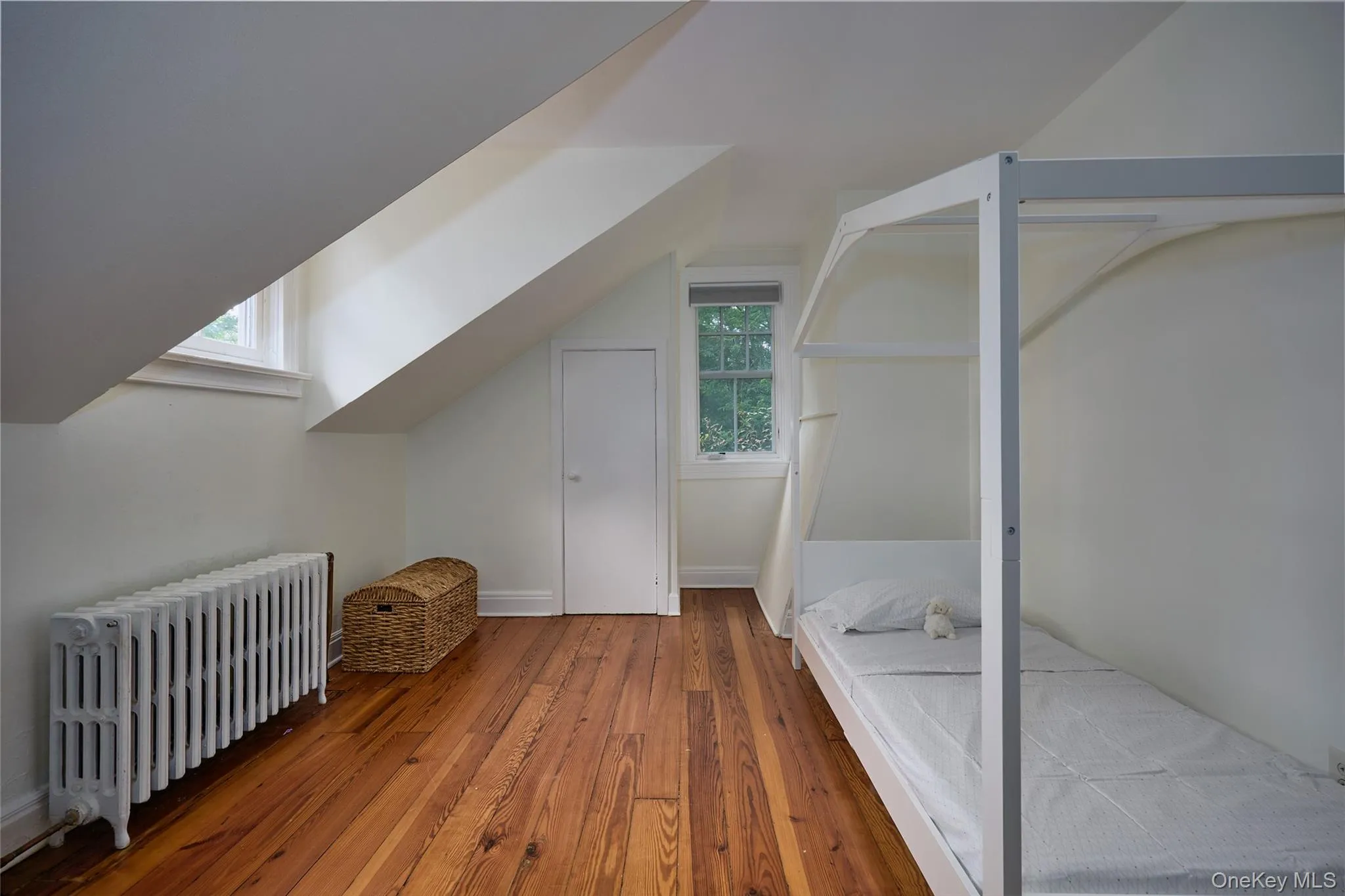 Bonus room featuring radiator, hardwood / wood-style flooring, plenty of natural light, and lofted ceiling Bonus room featuring radiator, hardwood / wood-style flooring, plenty of natural light, and lofted ceiling