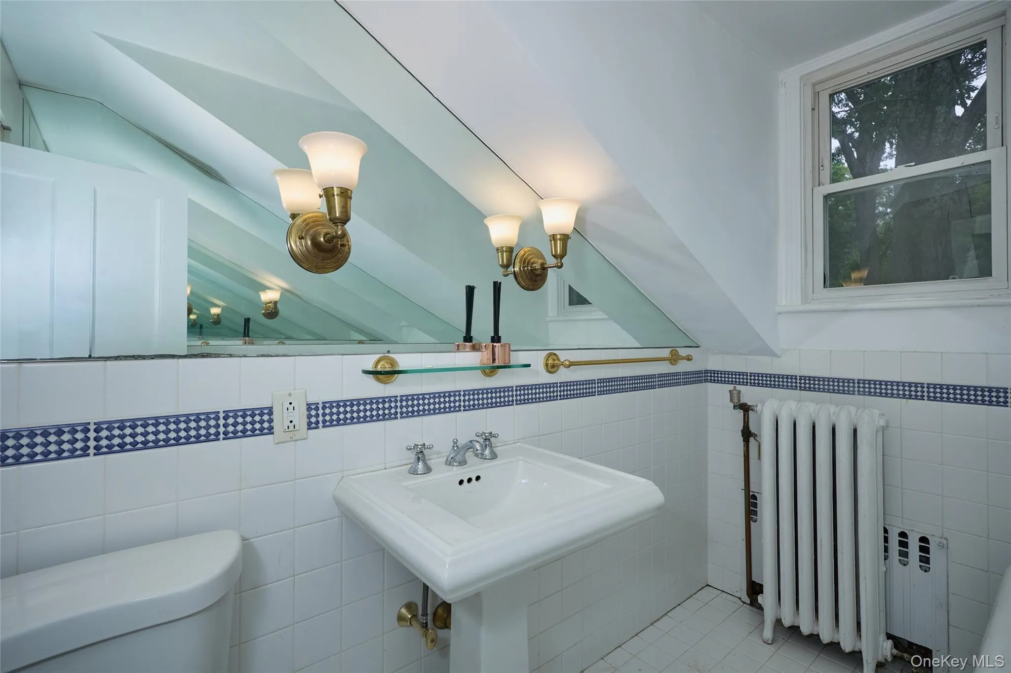 Half bath featuring radiator heating unit, tile walls, tile patterned floors, and lofted ceiling Half bath featuring radiator heating unit, tile walls, tile patterned floors, and lofted ceiling