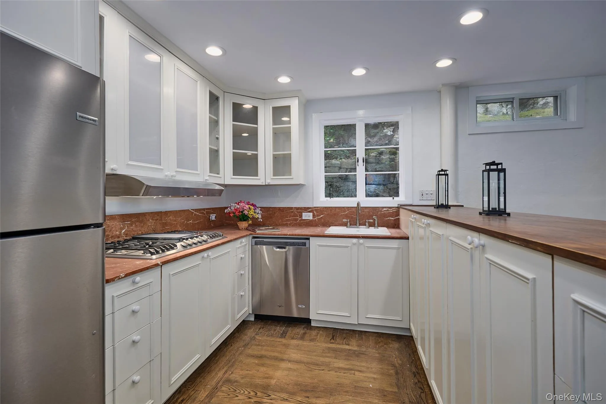 Kitchen with wooden counters, appliances with stainless steel finishes, recessed lighting, dark wood-style floors, and white cabinets Kitchen with wooden counters, appliances with stainless steel finishes, recessed lighting, dark wood-style floors, and white cabinets