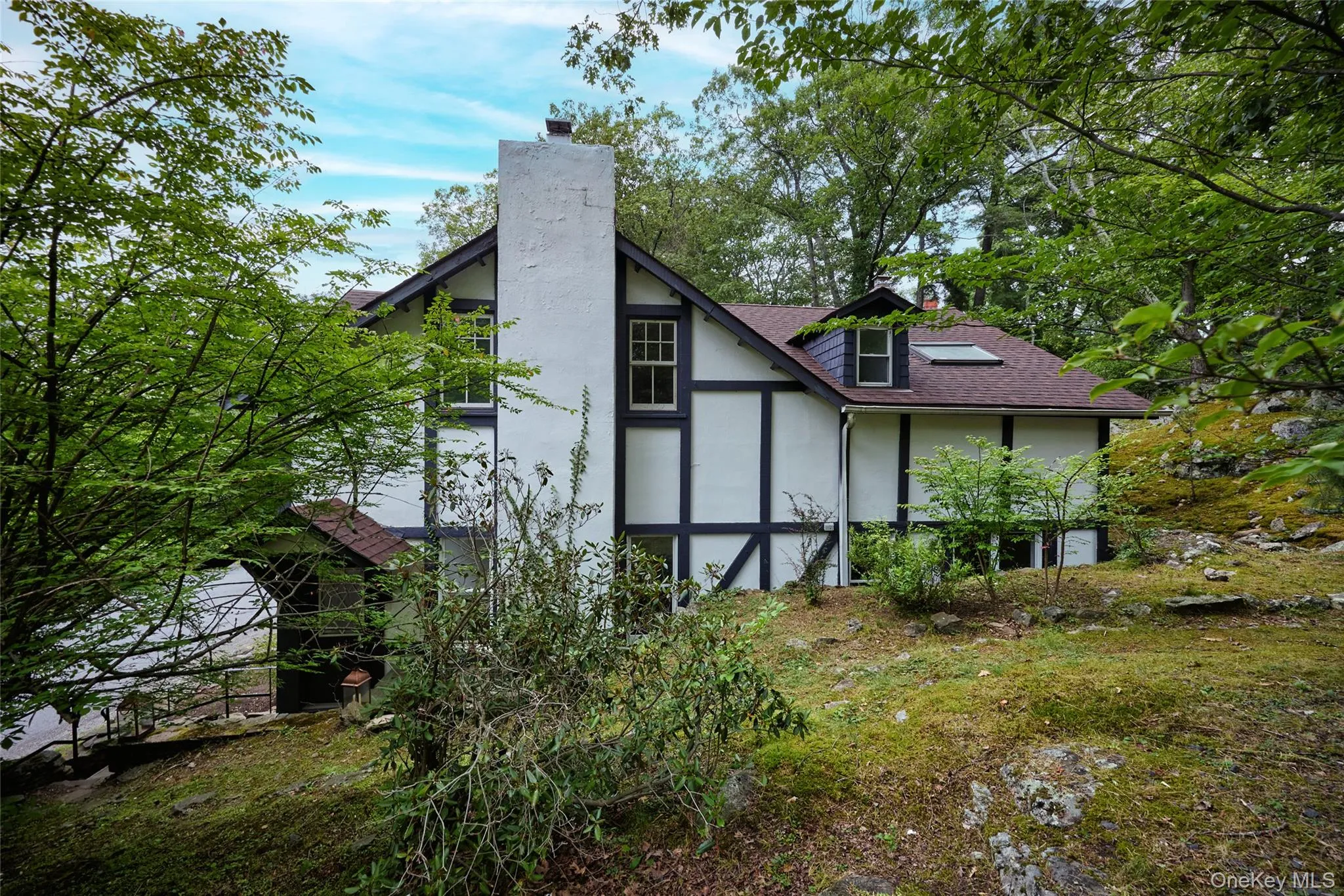 Back of property with a chimney, roof with shingles, and stucco siding Back of property with a chimney, roof with shingles, and stucco siding