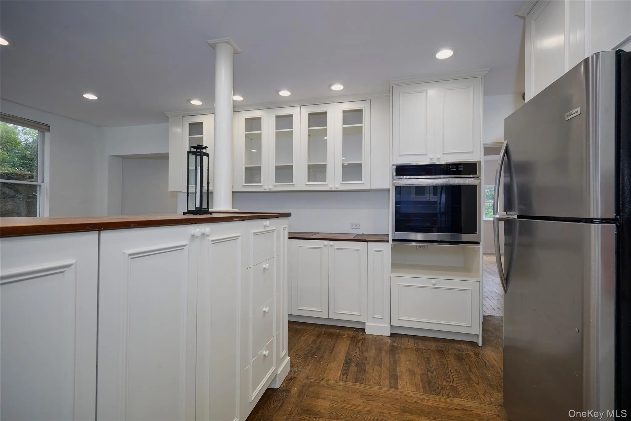 Kitchen featuring glass insert cabinets, stainless steel appliances, wooden counters, dark wood-style flooring, and recessed lighting Kitchen featuring glass insert cabinets, stainless steel appliances, wooden counters, dark wood-style flooring, and recessed lighting