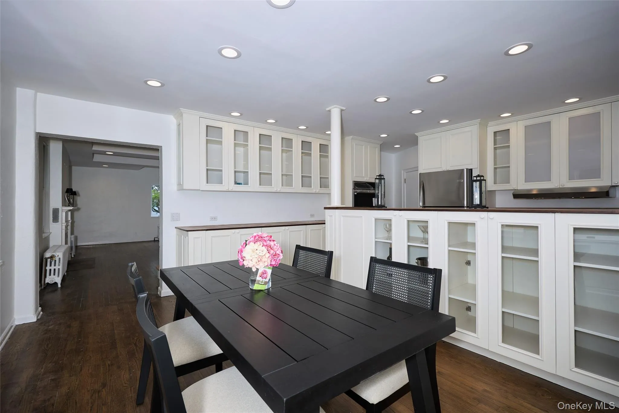 Dining area featuring dark wood-type flooring, recessed lighting, and radiator Dining area featuring dark wood-type flooring, recessed lighting, and radiator