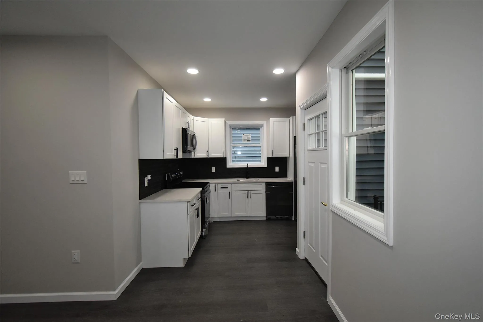 Kitchen featuring electric range oven, tasteful backsplash, white cabinets, dishwashing machine, and recessed lighting Kitchen featuring electric range oven, tasteful backsplash, white cabinets, dishwashing machine, and recessed lighting