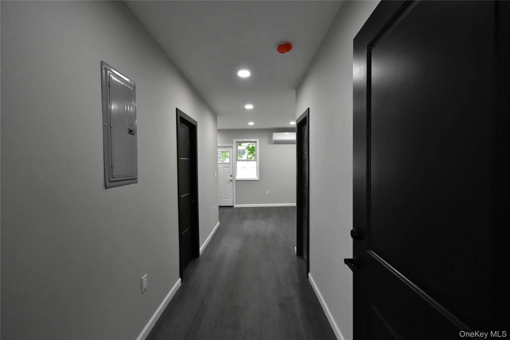 Hall featuring dark wood-style flooring, recessed lighting, and electric panel Hall featuring dark wood-style flooring, recessed lighting, and electric panel