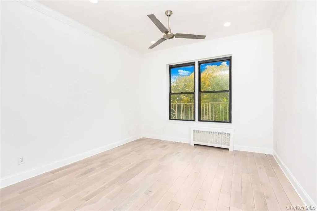 Spare room featuring ornamental molding, radiator heating unit, light wood-style flooring, a ceiling fan, and recessed lighting Spare room featuring ornamental molding, radiator heating unit, light wood-style flooring, a ceiling fan, and recessed lighting