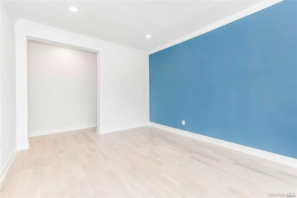 Empty room with ornamental molding, light wood-style flooring, and recessed lighting Empty room with ornamental molding, light wood-style flooring, and recessed lighting