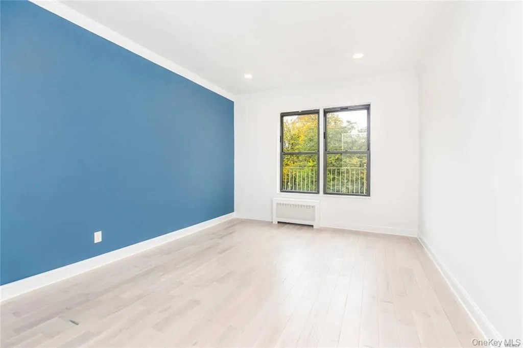 Unfurnished room featuring radiator, light wood-type flooring, recessed lighting, and ornamental molding Unfurnished room featuring radiator, light wood-type flooring, recessed lighting, and ornamental molding