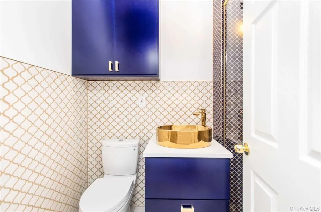 Half bathroom featuring tile walls and vanity Half bathroom featuring tile walls and vanity