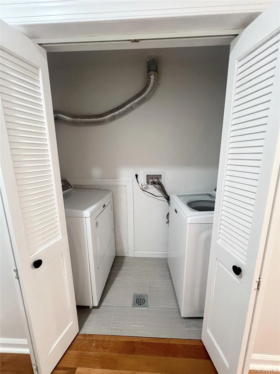 Laundry area featuring light wood-style flooring and washing machine and dryer Laundry area featuring light wood-style flooring and washing machine and dryer