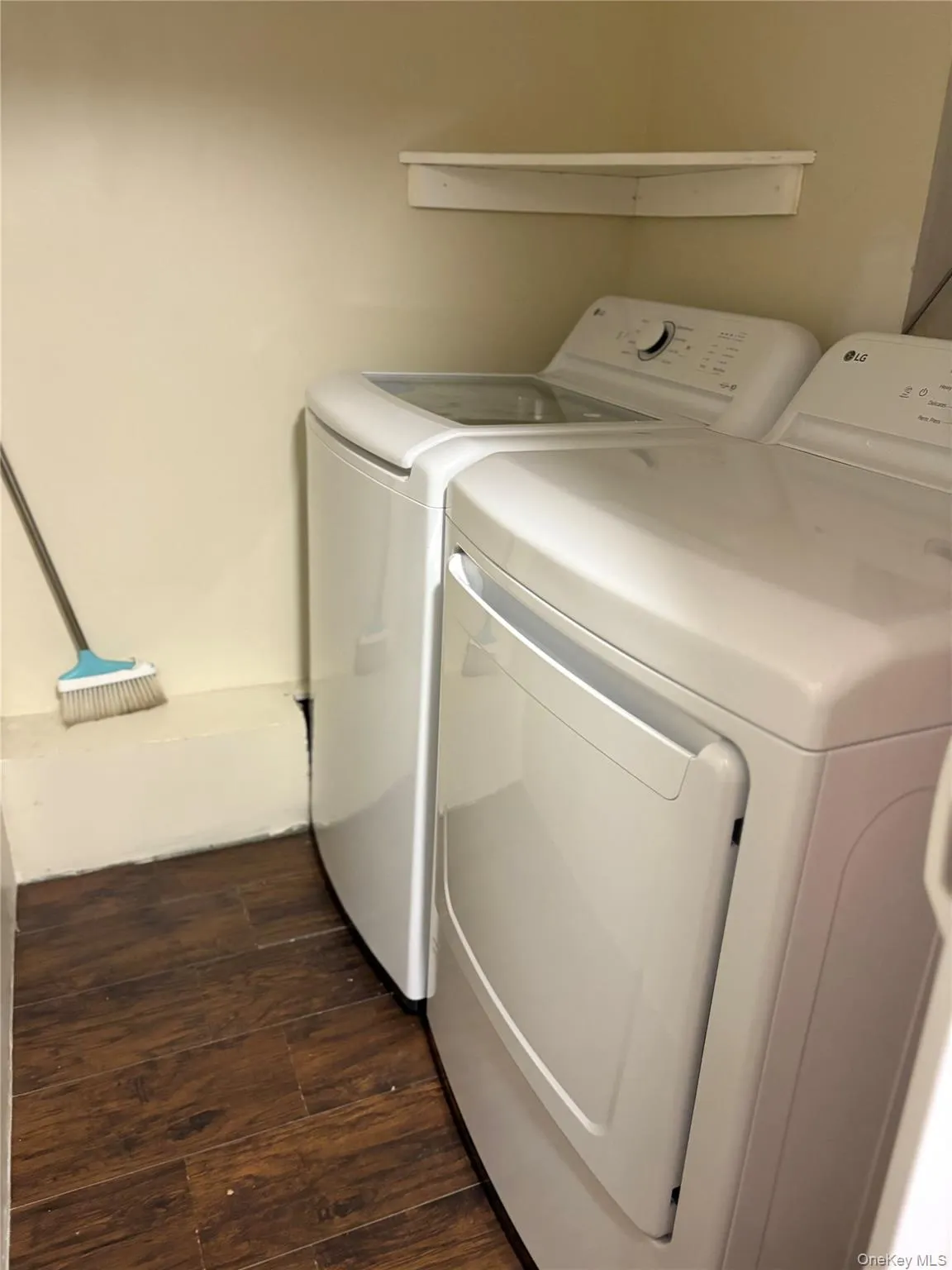 Laundry area featuring washer and clothes dryer and dark wood-style floors Laundry area featuring washer and clothes dryer and dark wood-style floors