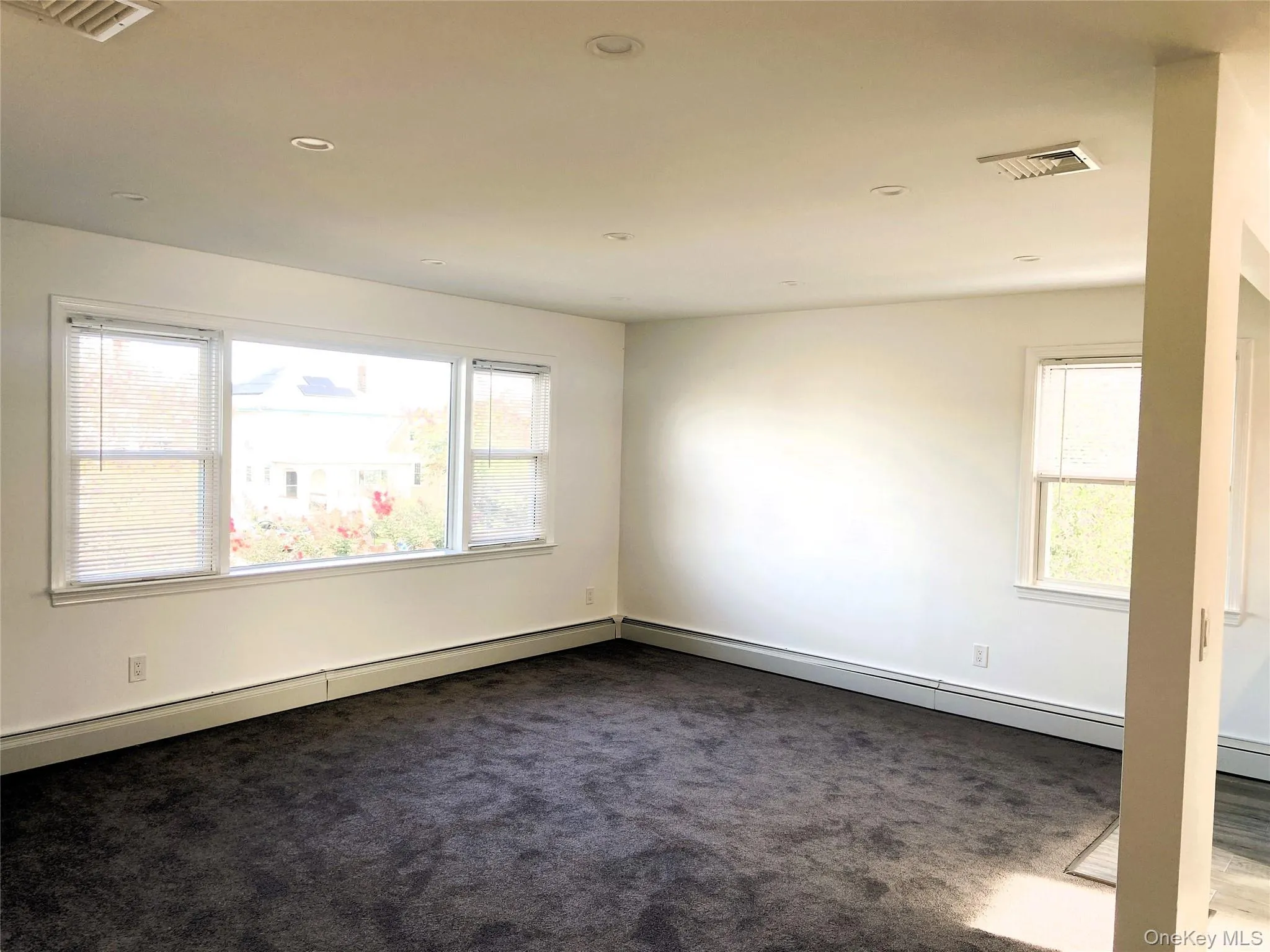 Spare room featuring dark carpet, recessed lighting, and a baseboard heating unit Spare room featuring dark carpet, recessed lighting, and a baseboard heating unit
