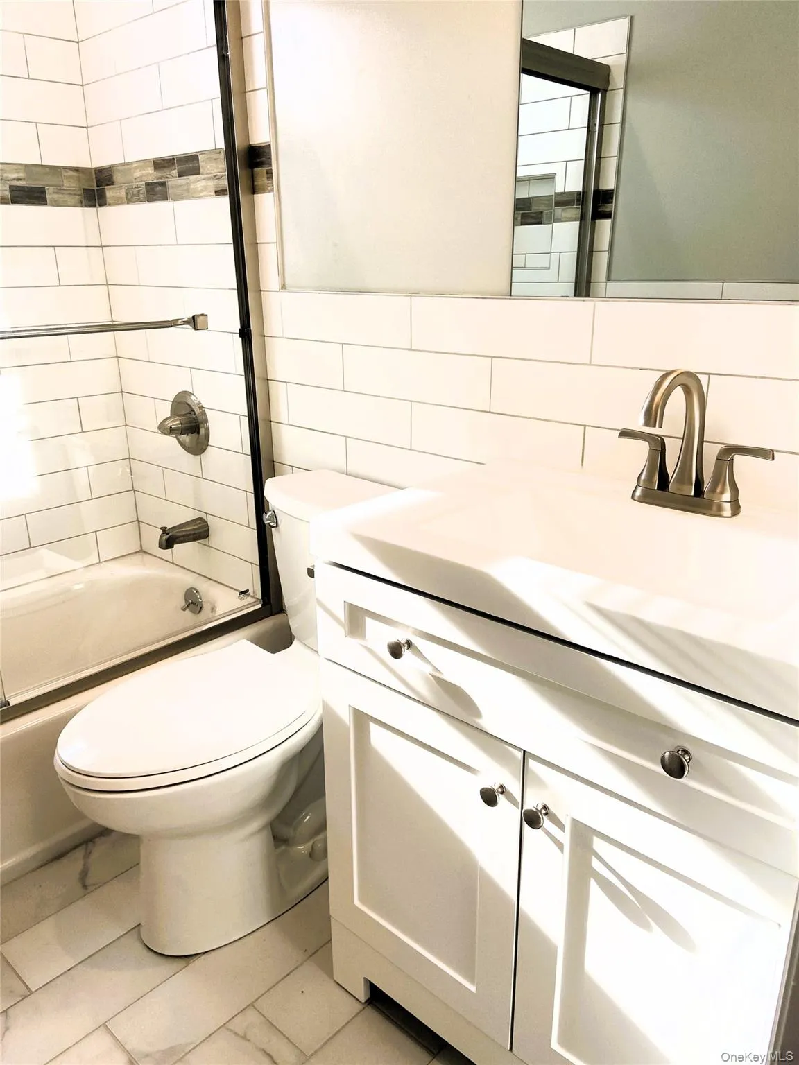 Full bath featuring vanity, shower / bathtub combination, tile walls, and backsplash Full bath featuring vanity, shower / bathtub combination, tile walls, and backsplash