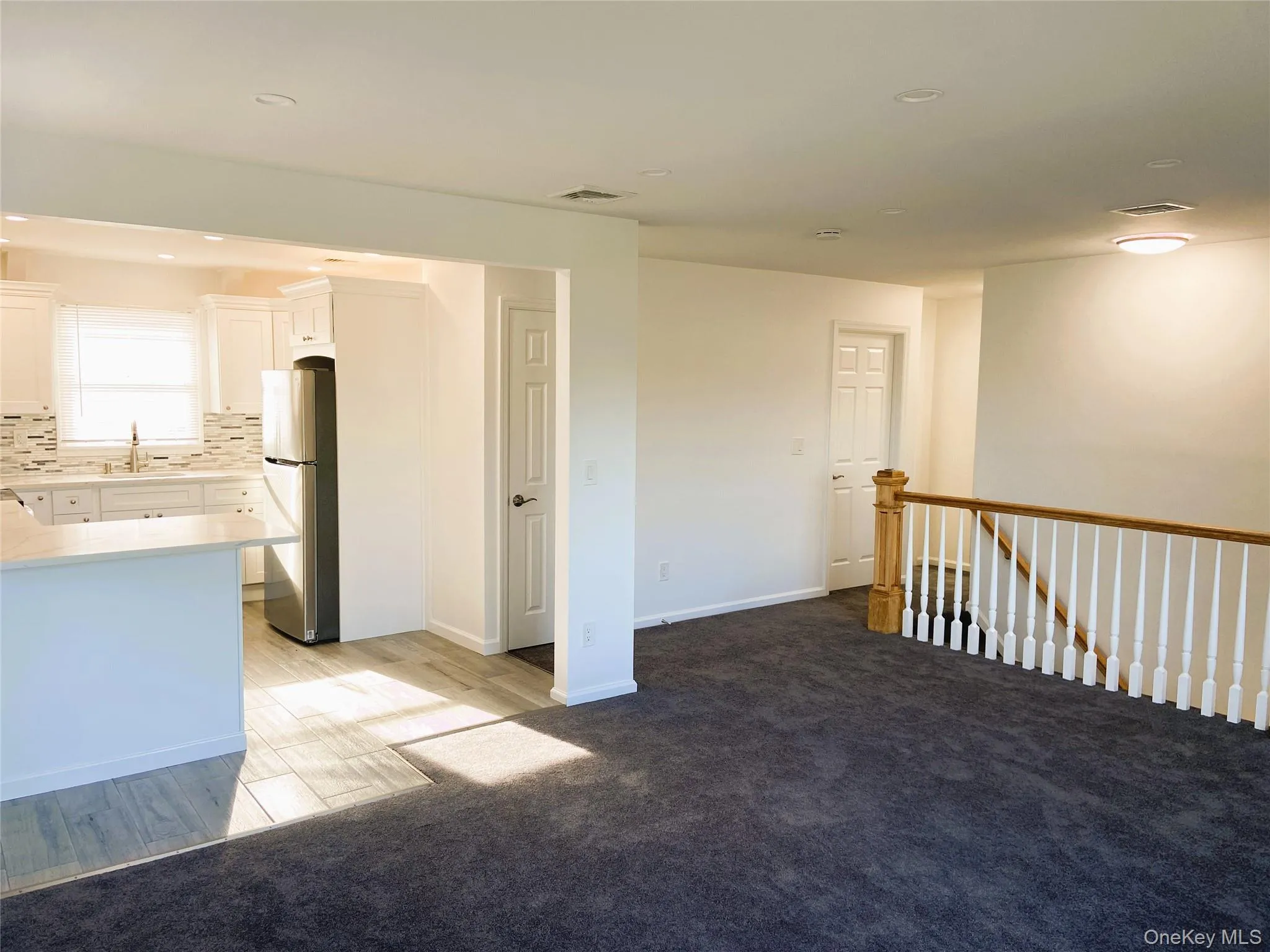 Spare room with light carpet, recessed lighting, and light wood-style floors Spare room with light carpet, recessed lighting, and light wood-style floors