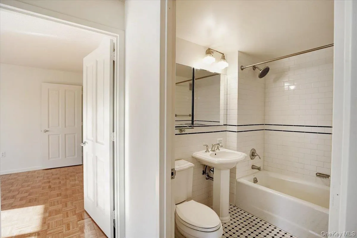 Bathroom featuring shower / bath combination and tile walls Bathroom featuring shower / bath combination and tile walls