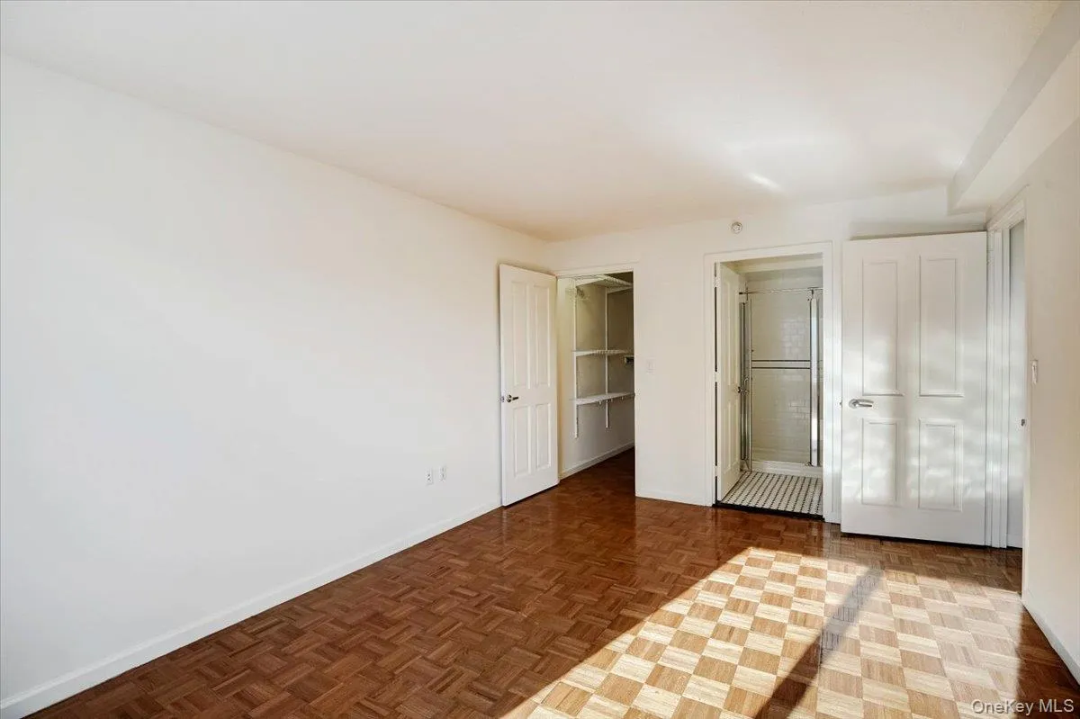 Unfurnished bedroom featuring ensuite bath and a walk in closet Unfurnished bedroom featuring ensuite bath and a walk in closet