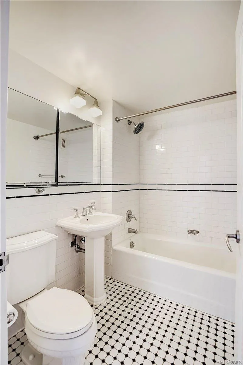 Full bath with tile walls, shower / washtub combination, and tile patterned flooring Full bath with tile walls, shower / washtub combination, and tile patterned flooring
