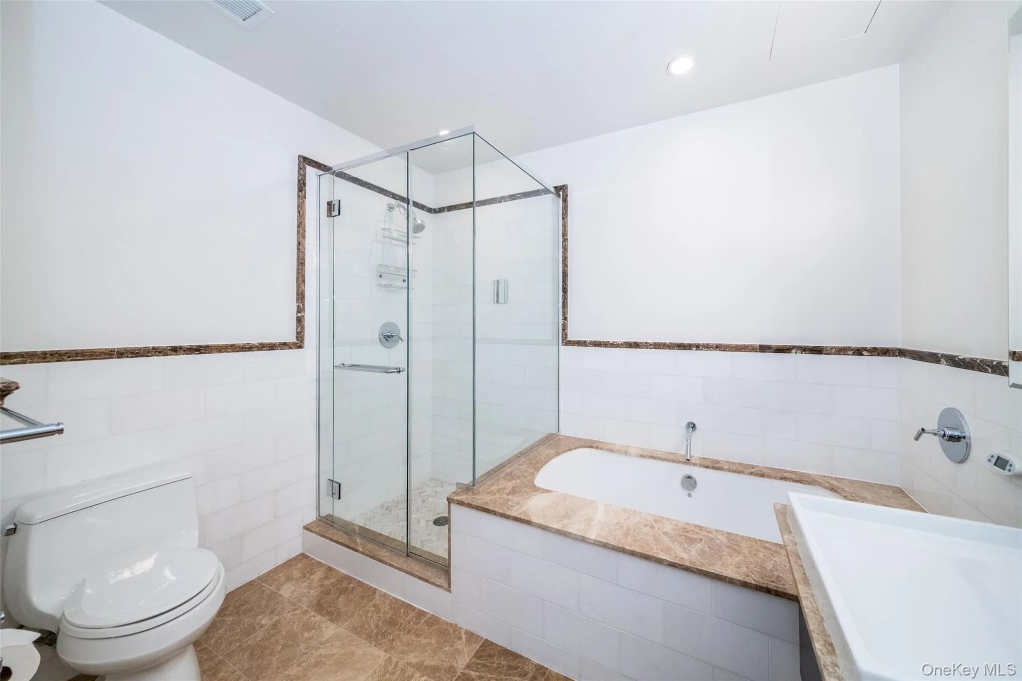 Bathroom with tile walls, a garden tub, a shower stall, a wainscoted wall, and recessed lighting Bathroom with tile walls, a garden tub, a shower stall, a wainscoted wall, and recessed lighting