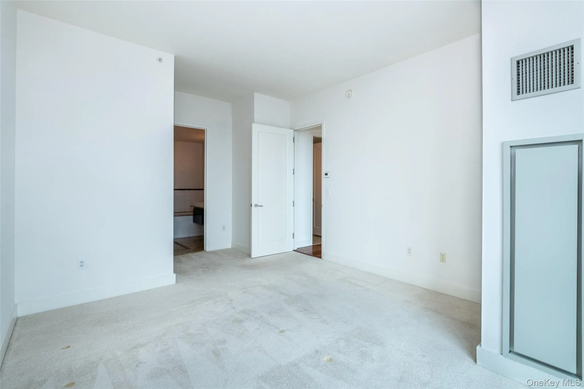 Unfurnished bedroom featuring carpet flooring and ensuite bathroom Unfurnished bedroom featuring carpet flooring and ensuite bathroom