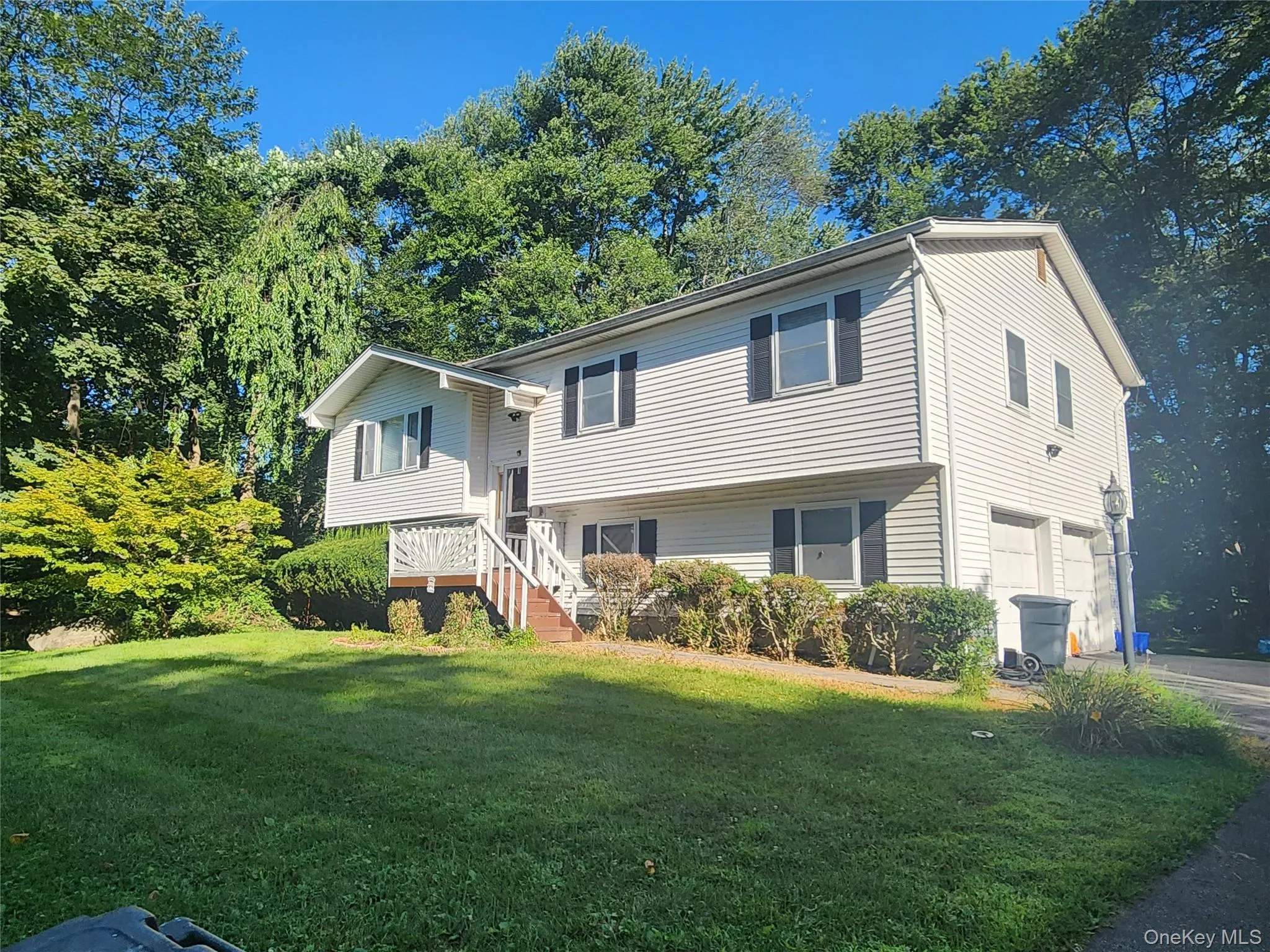 View of front of property featuring a front lawn and an attached garage View of front of property featuring a front lawn and an attached garage