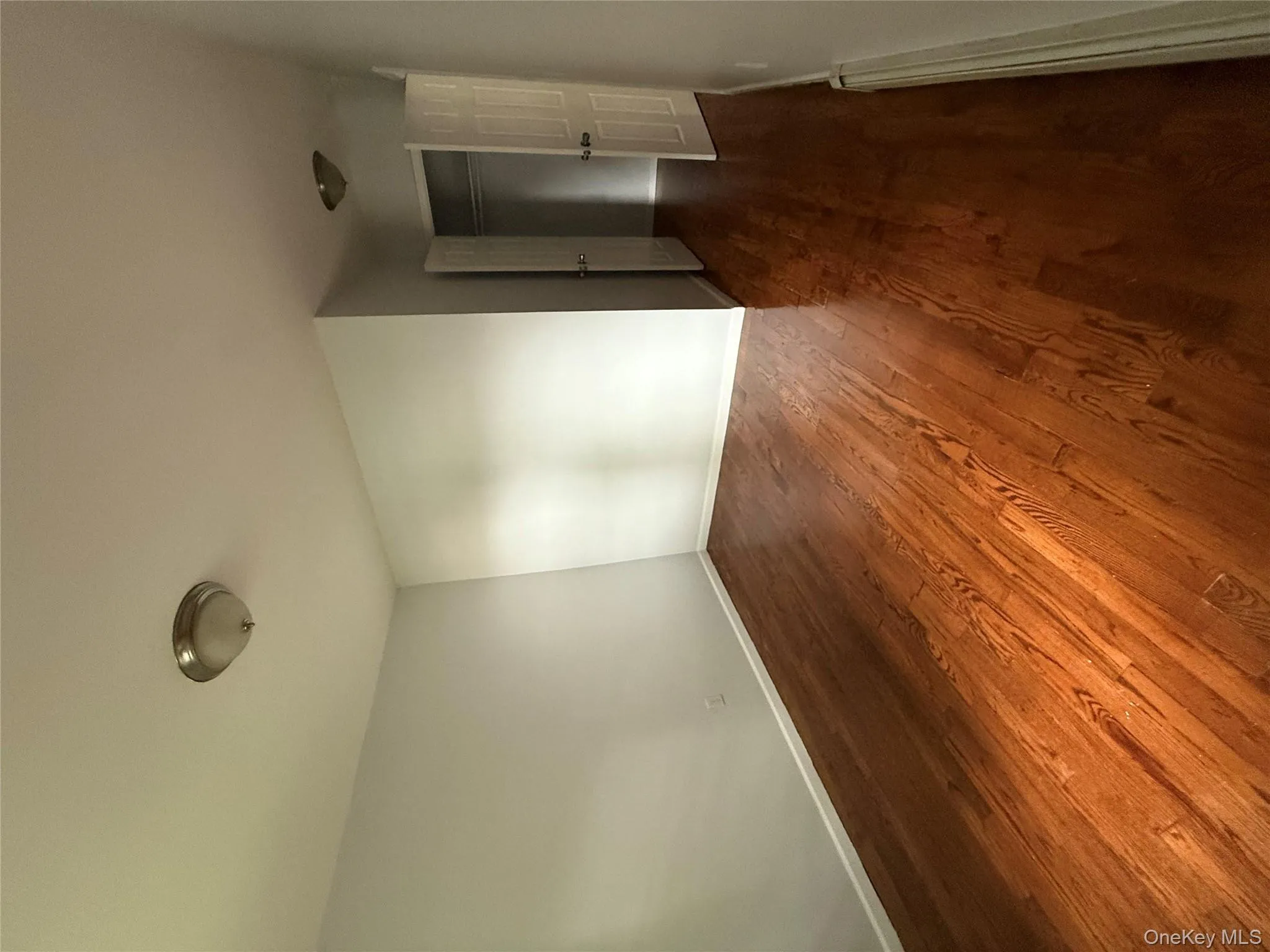 Spare room with dark wood-type flooring and a baseboard heating unit Spare room with dark wood-type flooring and a baseboard heating unit