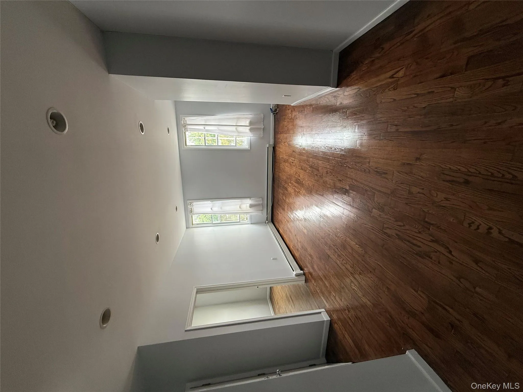 Empty room with dark wood-type flooring and recessed lighting Empty room with dark wood-type flooring and recessed lighting