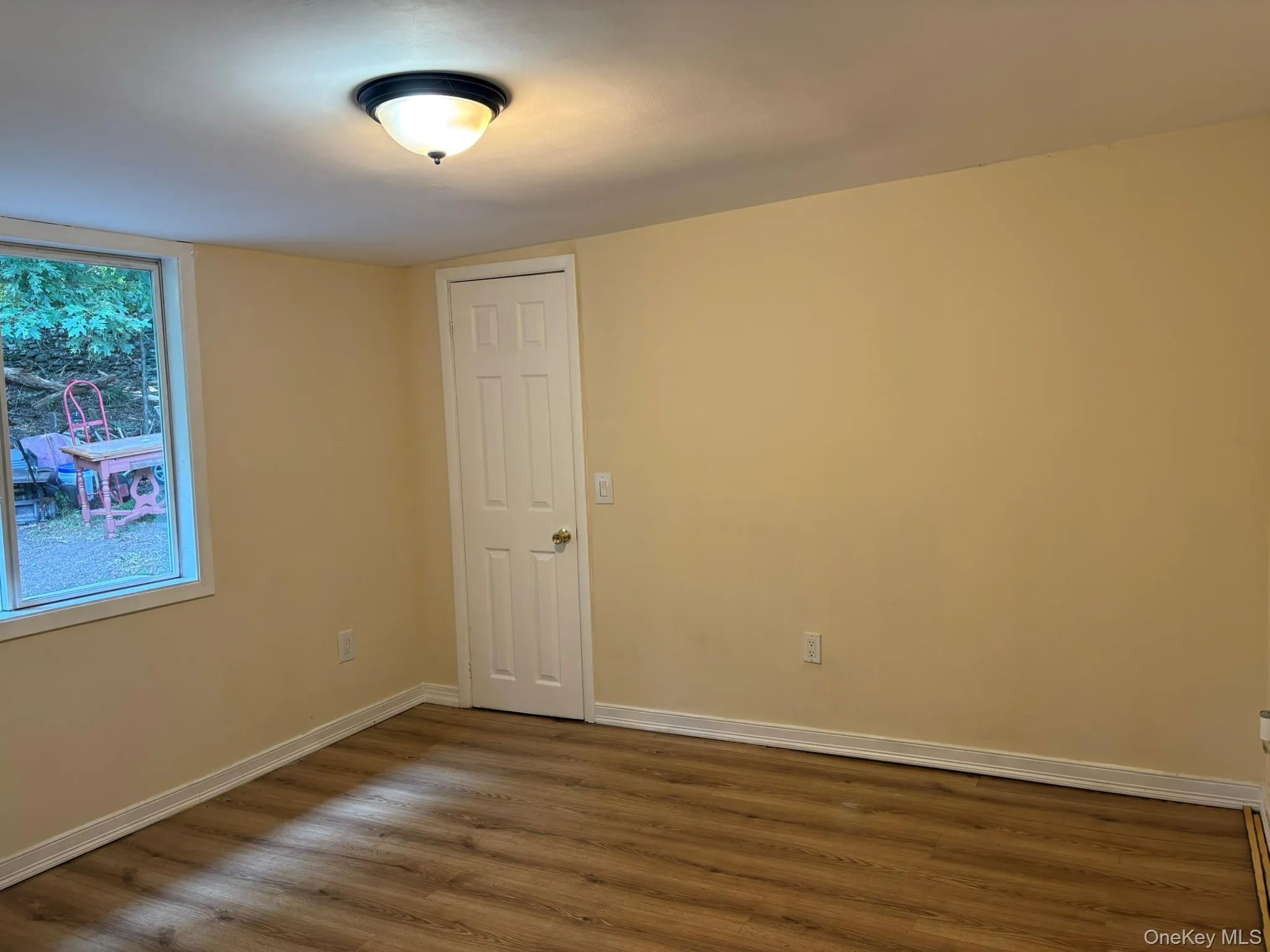 Spare room with wood finished floors and baseboards Spare room with wood finished floors and baseboards
