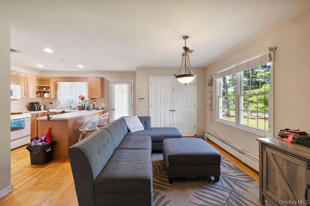 Living area with a baseboard heating unit, light wood finished floors, and recessed lighting Living area with a baseboard heating unit, light wood finished floors, and recessed lighting