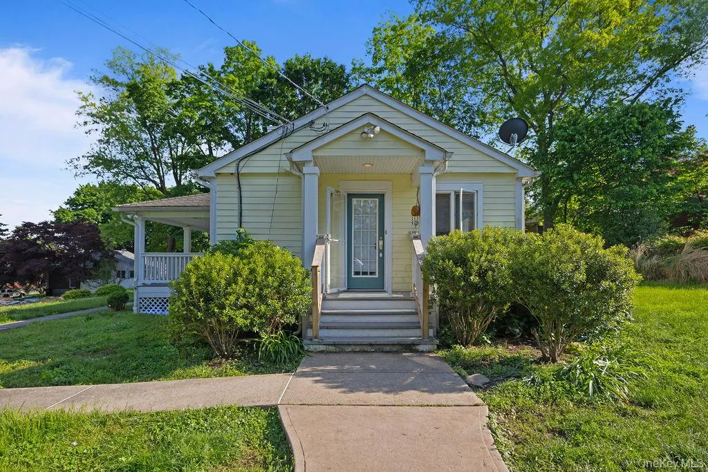 Bungalow-style house with a porch and a front lawn Bungalow-style house with a porch and a front lawn