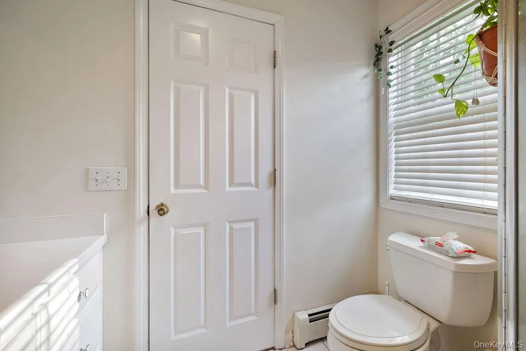Bathroom featuring a baseboard heating unit and vanity Bathroom featuring a baseboard heating unit and vanity