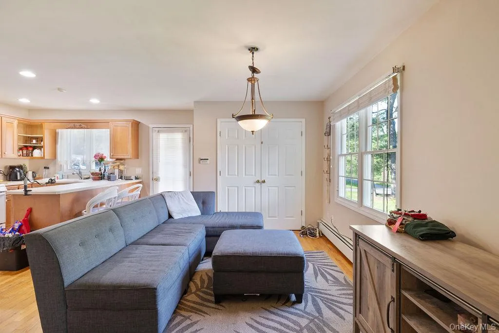 Living area with light wood-style flooring, a baseboard heating unit, and recessed lighting Living area with light wood-style flooring, a baseboard heating unit, and recessed lighting