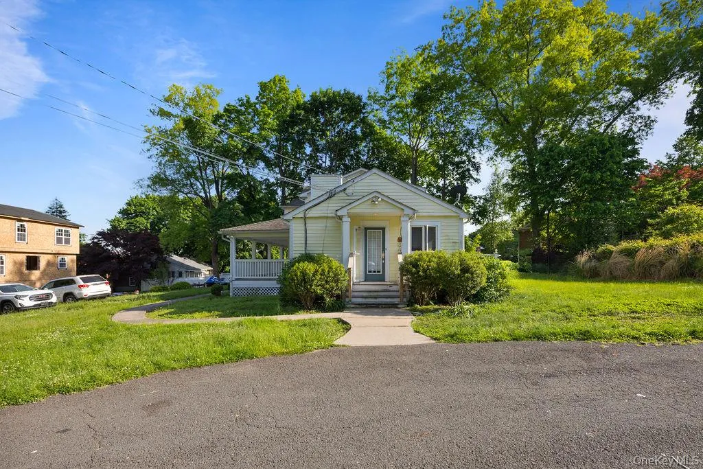Bungalow featuring a porch and a front lawn Bungalow featuring a porch and a front lawn