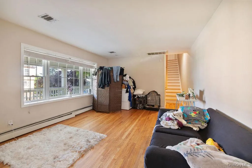 Living room with light wood finished floors and a baseboard radiator Living room with light wood finished floors and a baseboard radiator