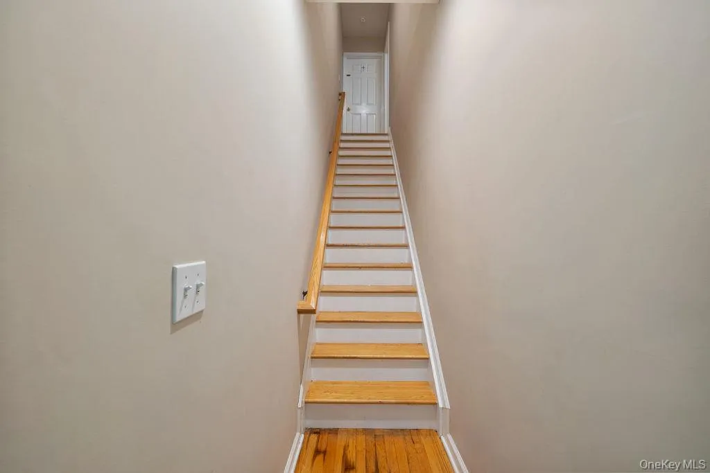 Staircase featuring baseboards and wood finished floors Staircase featuring baseboards and wood finished floors