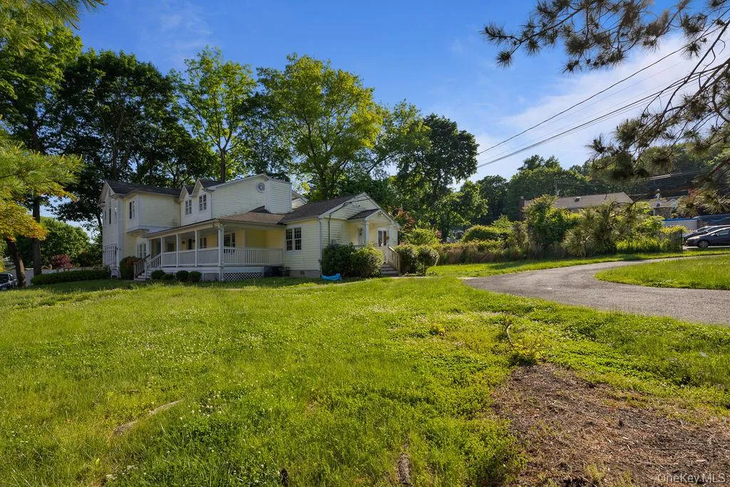 View of side of home with covered porch, a yard, crawl space, and asphalt driveway View of side of home with covered porch, a yard, crawl space, and asphalt driveway