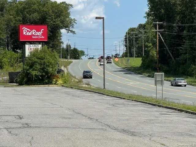 View of asphalt road with street lights and curbs View of asphalt road with street lights and curbs