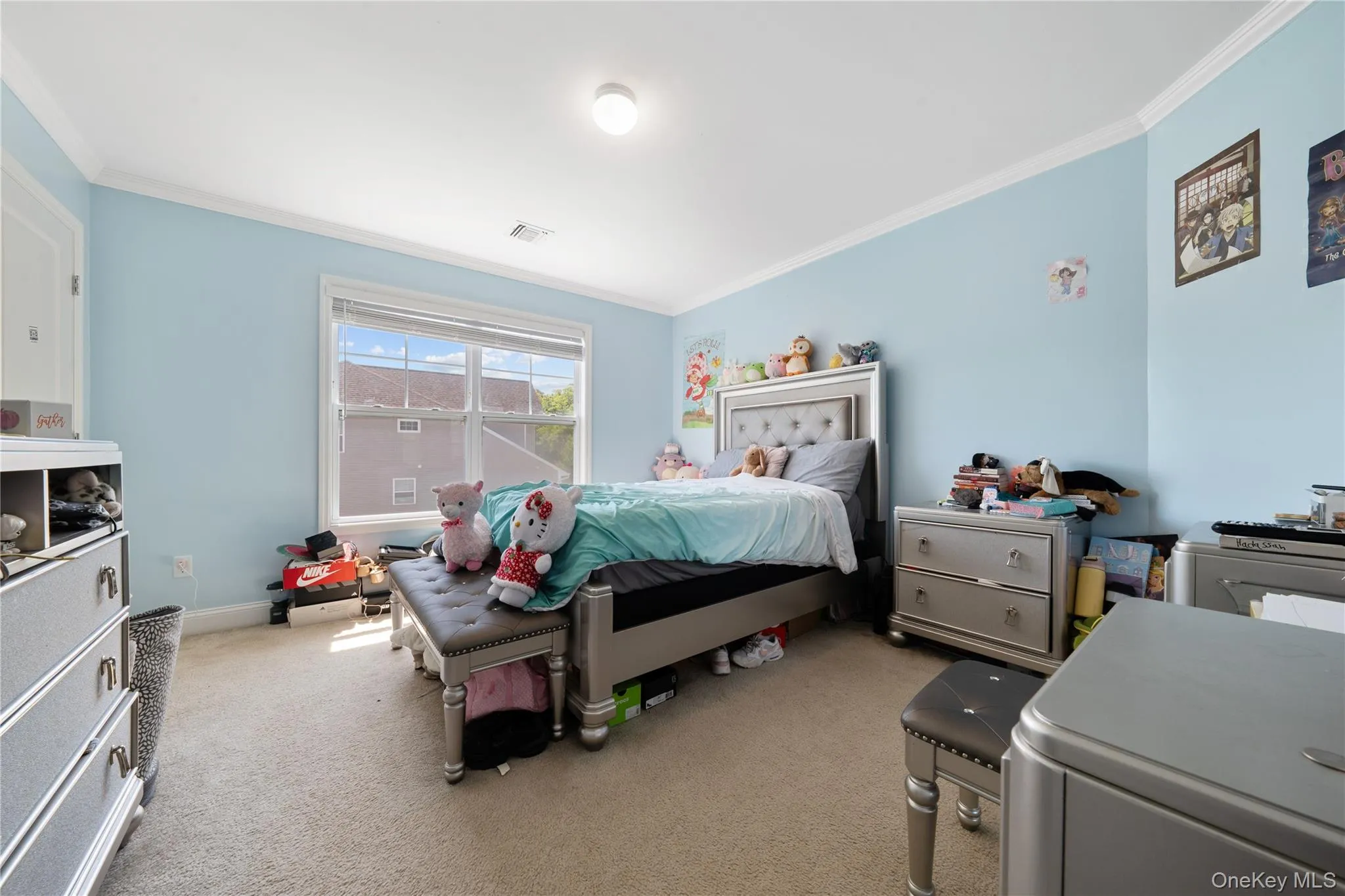 Bedroom featuring ornamental molding and light colored carpet Bedroom featuring ornamental molding and light colored carpet