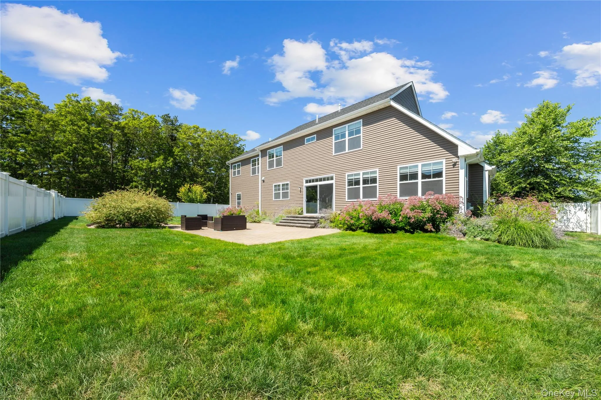Back of property featuring a fenced backyard, a patio area, and an outdoor living space Back of property featuring a fenced backyard, a patio area, and an outdoor living space