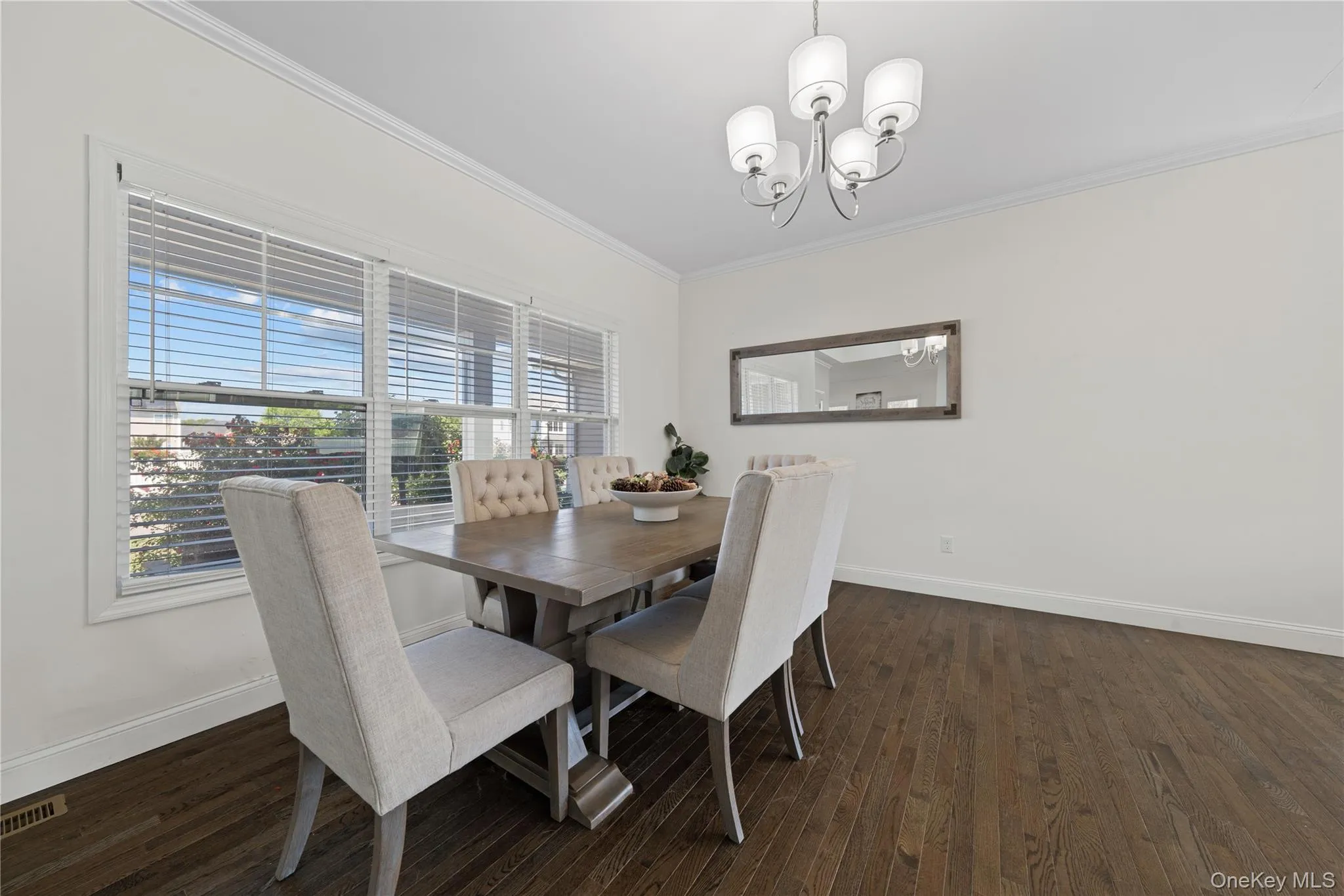 Dining space with crown molding, dark wood finished floors, and a chandelier Dining space with crown molding, dark wood finished floors, and a chandelier