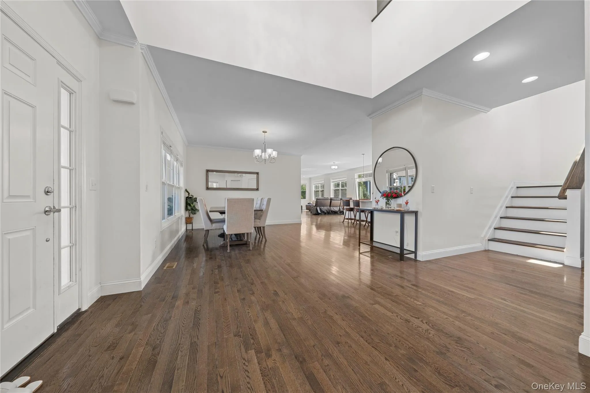 Entrance foyer featuring crown molding, dark wood finished floors, stairway, a chandelier, and recessed lighting Entrance foyer featuring crown molding, dark wood finished floors, stairway, a chandelier, and recessed lighting