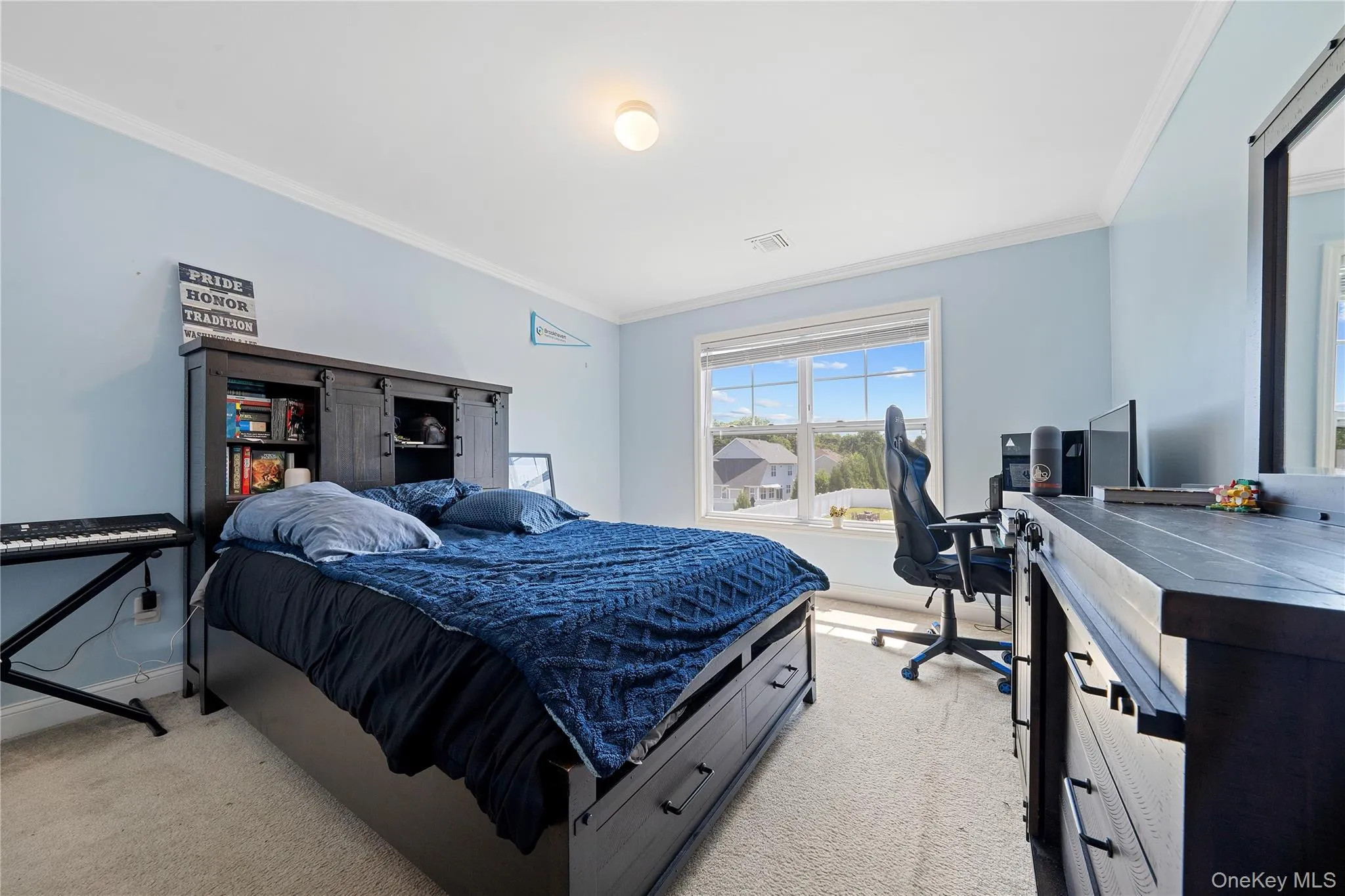 Bedroom with crown molding, light carpet, and an office area Bedroom with crown molding, light carpet, and an office area