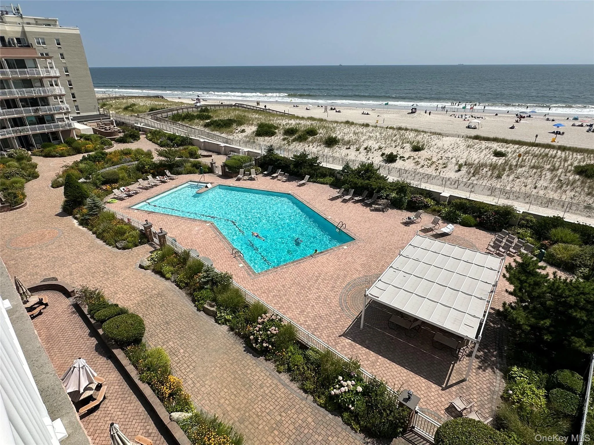 Community pool featuring view of water and beach Community pool featuring view of water and beach