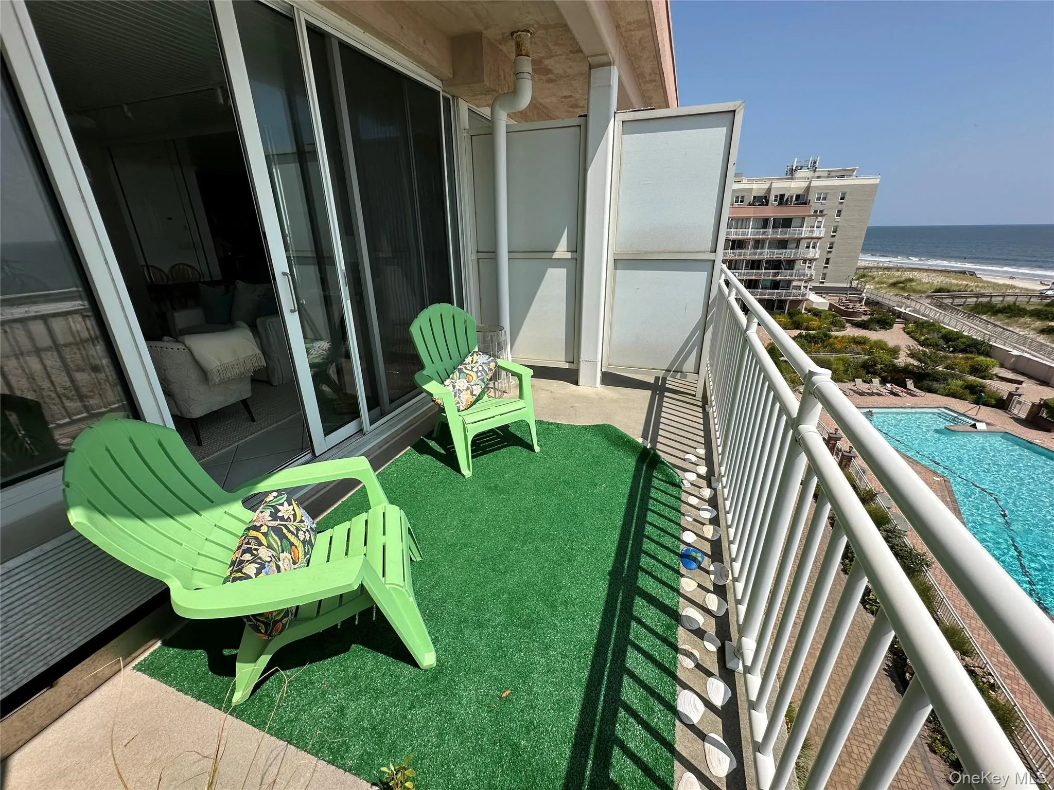 Balcony with view of water and beach and view of pool area Balcony with view of water and beach and view of pool area