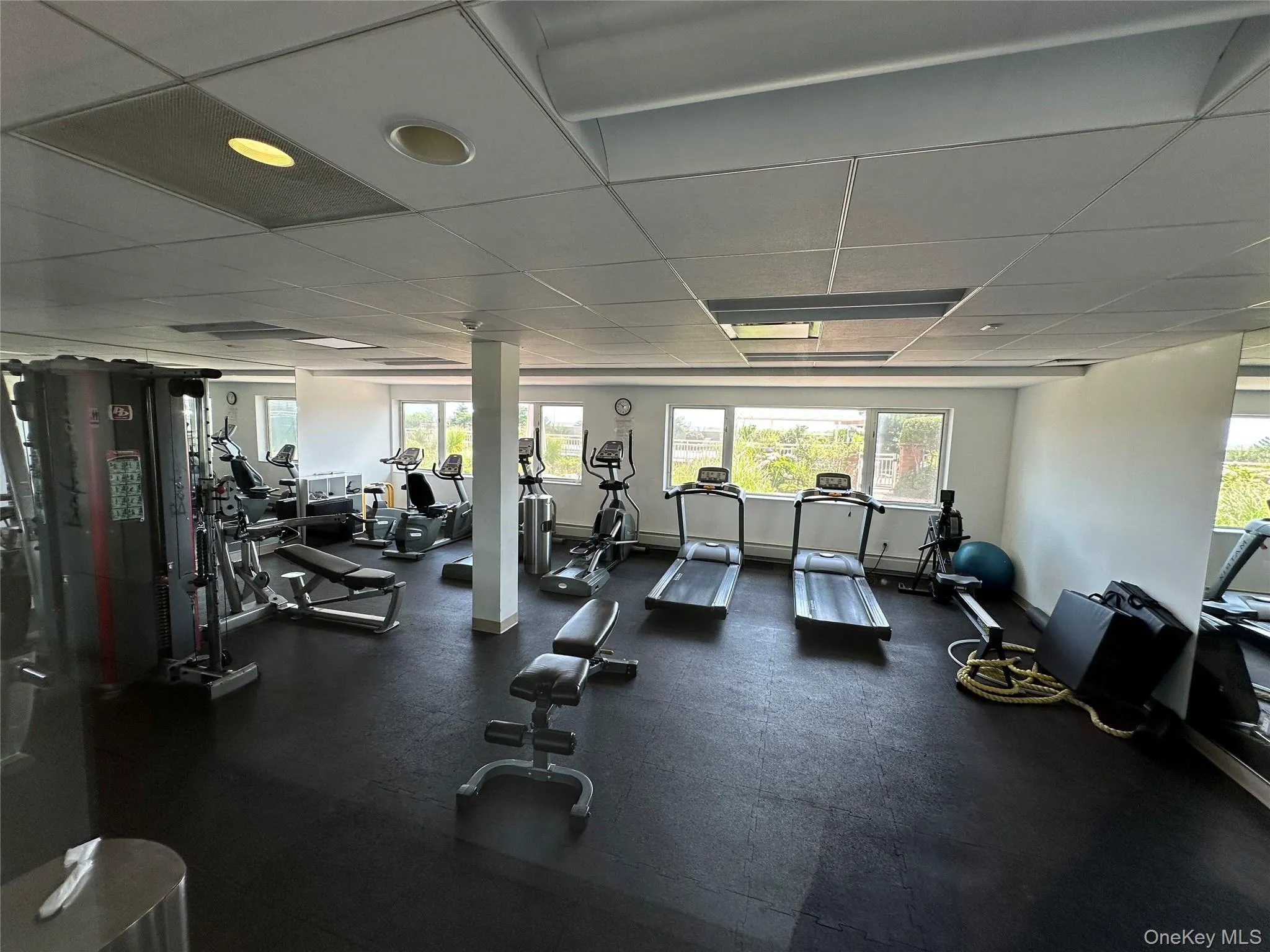 Workout area featuring a paneled ceiling and baseboards Workout area featuring a paneled ceiling and baseboards