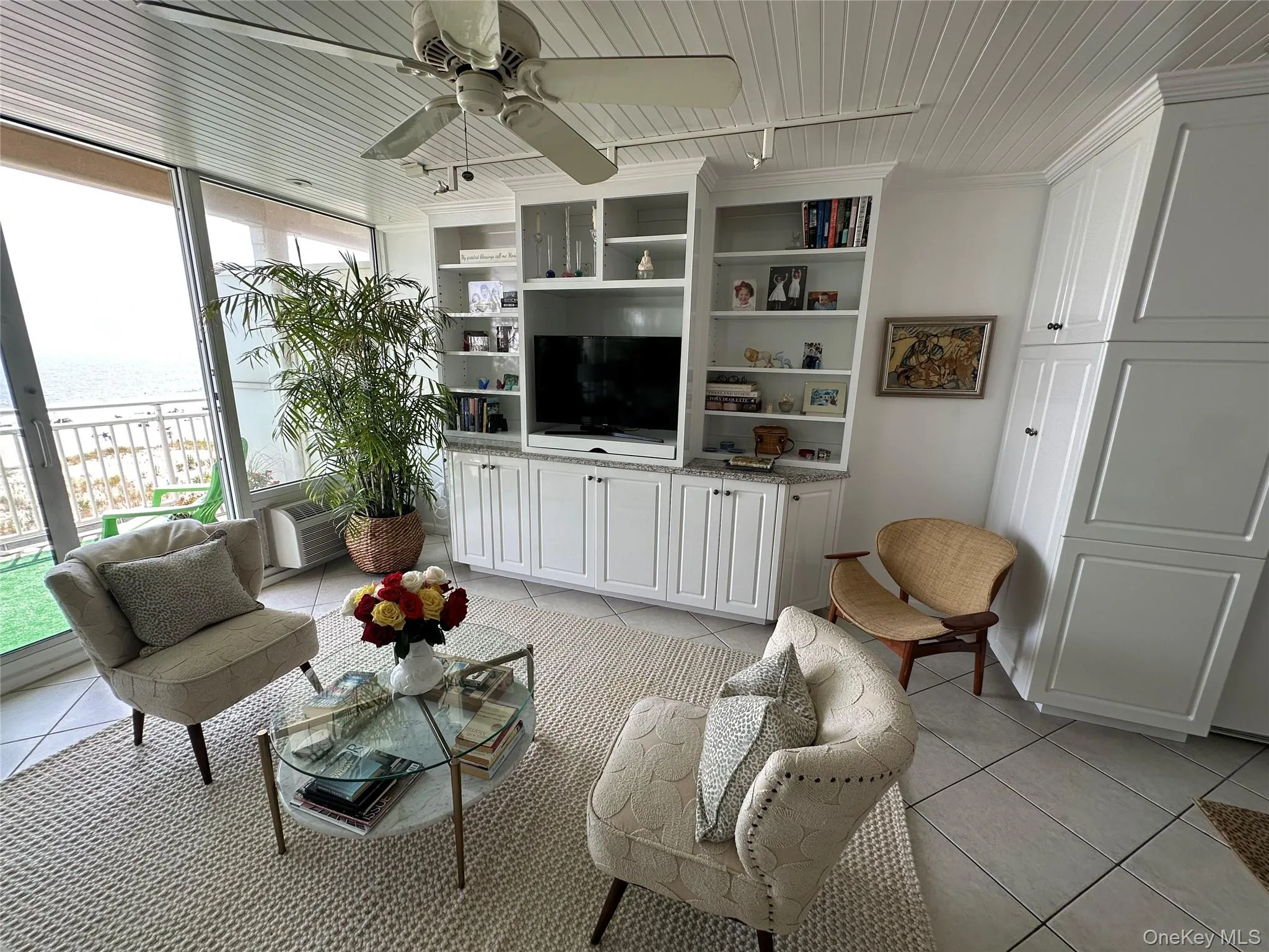 Living room with light tile patterned floors, a water view, floor to ceiling windows, ceiling fan, and wooden ceiling Living room with light tile patterned floors, a water view, floor to ceiling windows, ceiling fan, and wooden ceiling