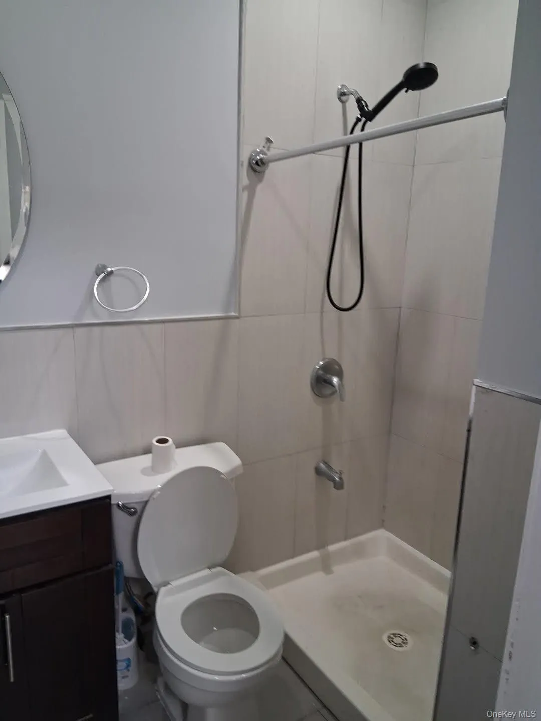 Full bathroom with vanity, a stall shower, and tile walls Full bathroom with vanity, a stall shower, and tile walls