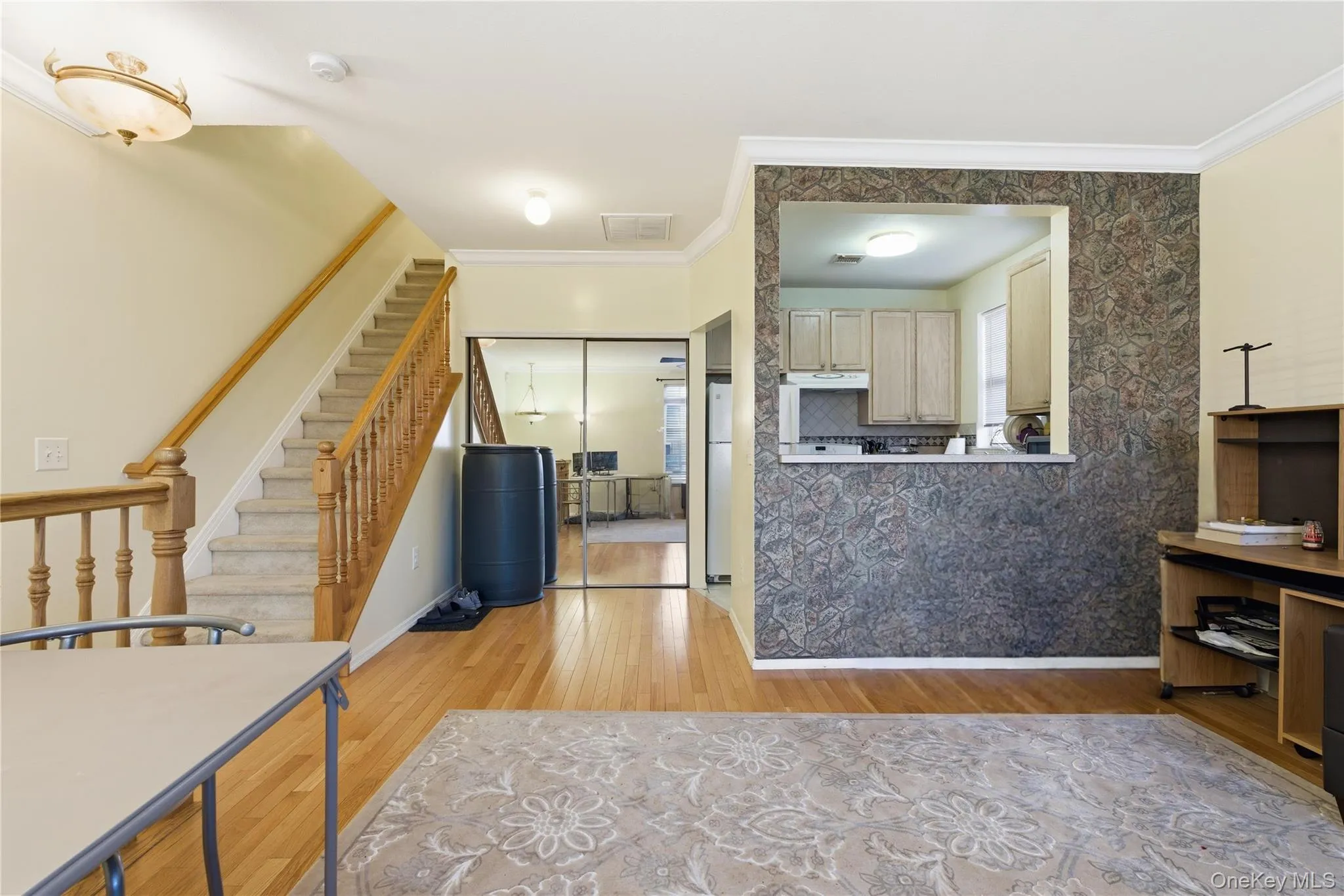 Kitchen featuring light wood finished floors, ornamental molding, light brown cabinetry, and freestanding refrigerator Kitchen featuring light wood finished floors, ornamental molding, light brown cabinetry, and freestanding refrigerator