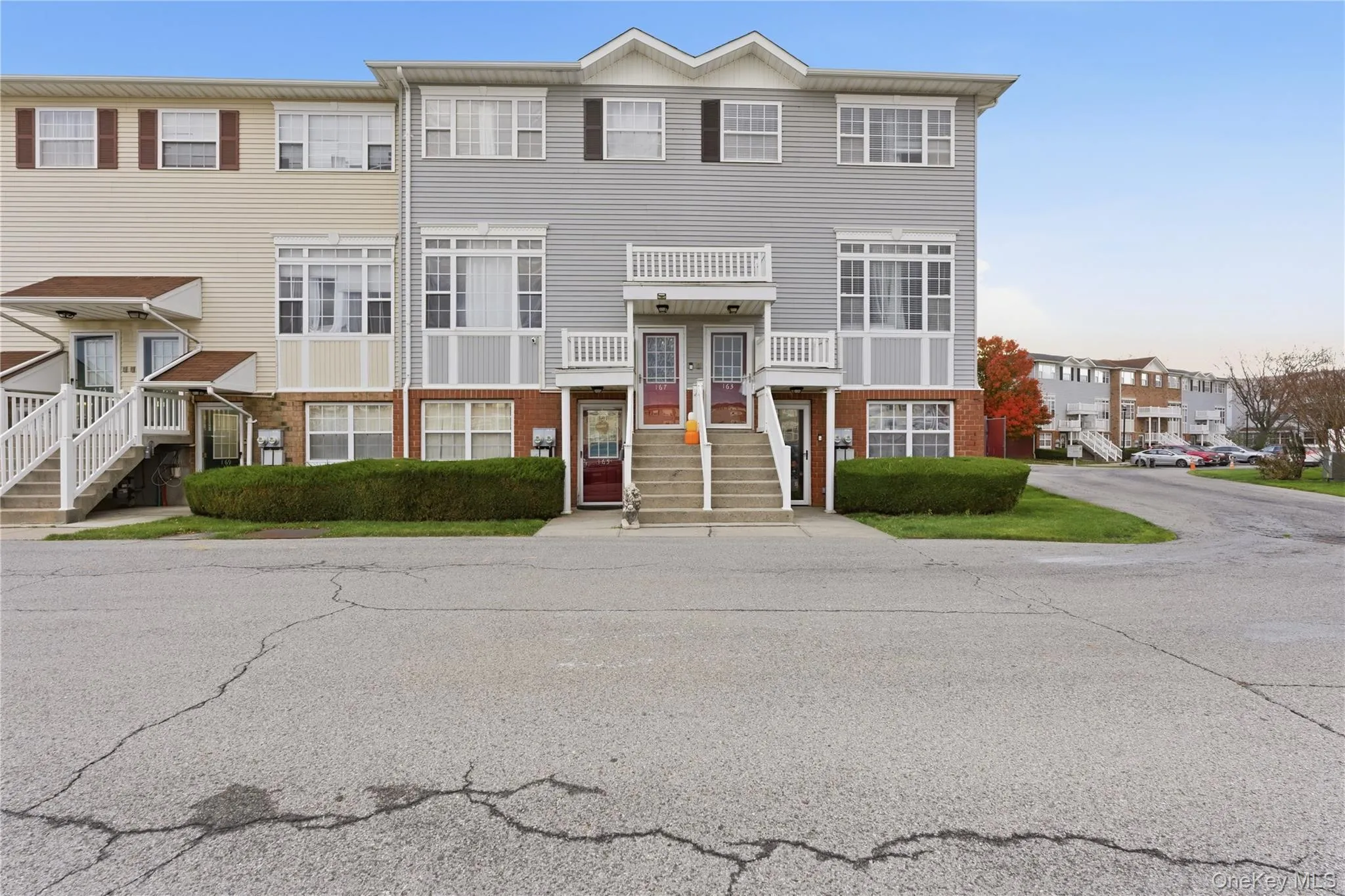 View of front facade with brick siding, a balcony, and stairs View of front facade with brick siding, a balcony, and stairs