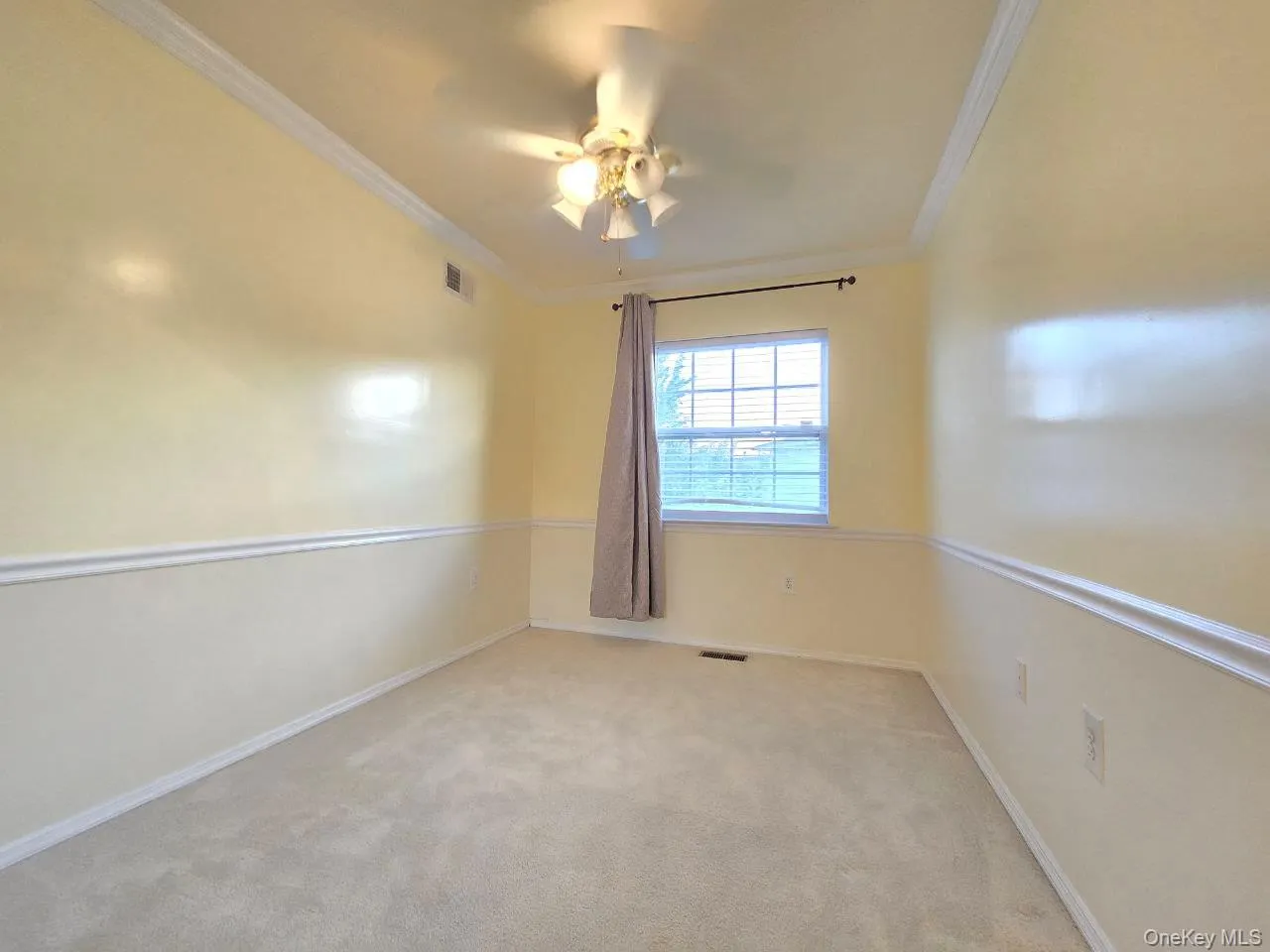 Empty room with crown molding, light carpet, and ceiling fan Empty room with crown molding, light carpet, and ceiling fan